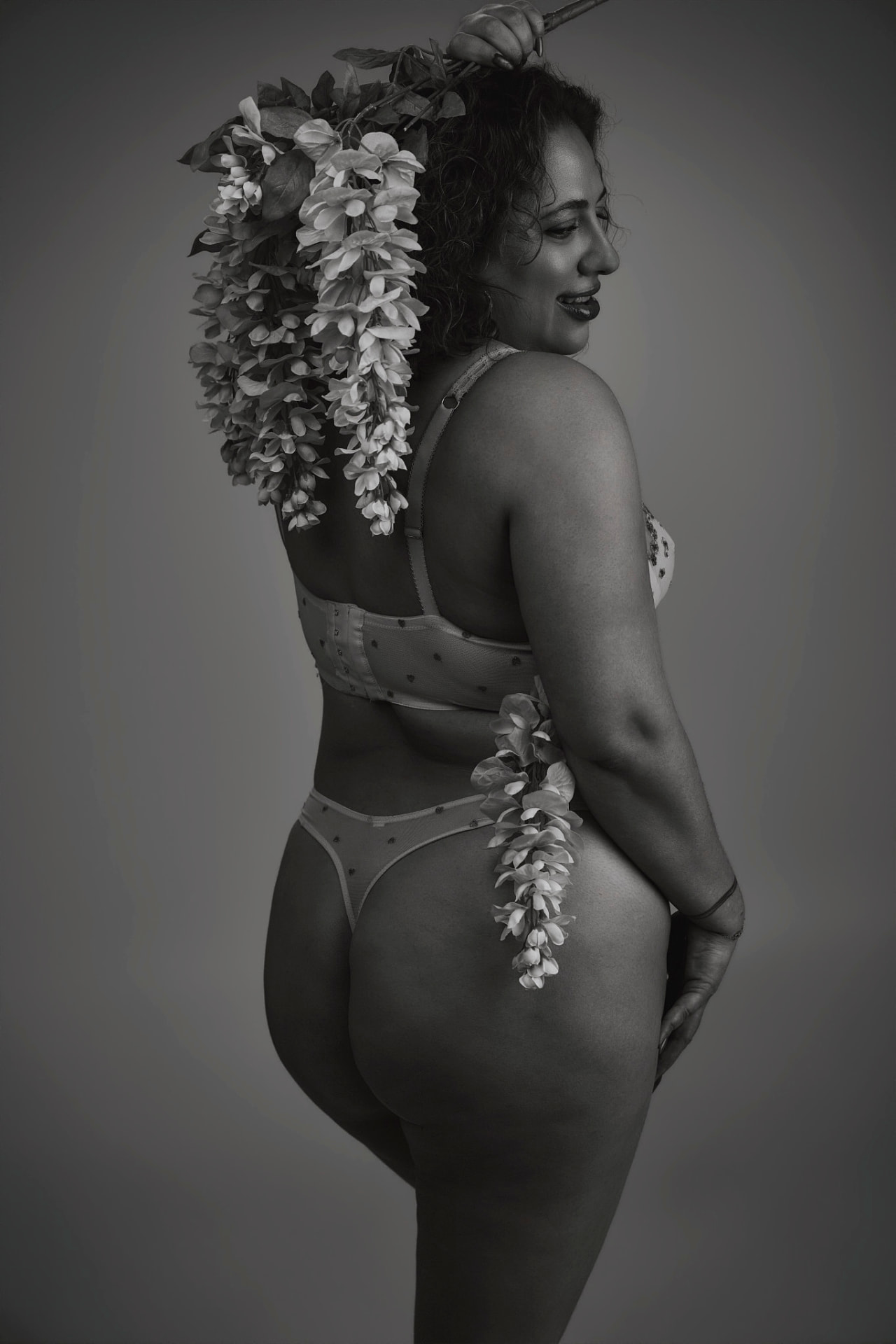 Black-and-white boudoir portrait with cascading florals