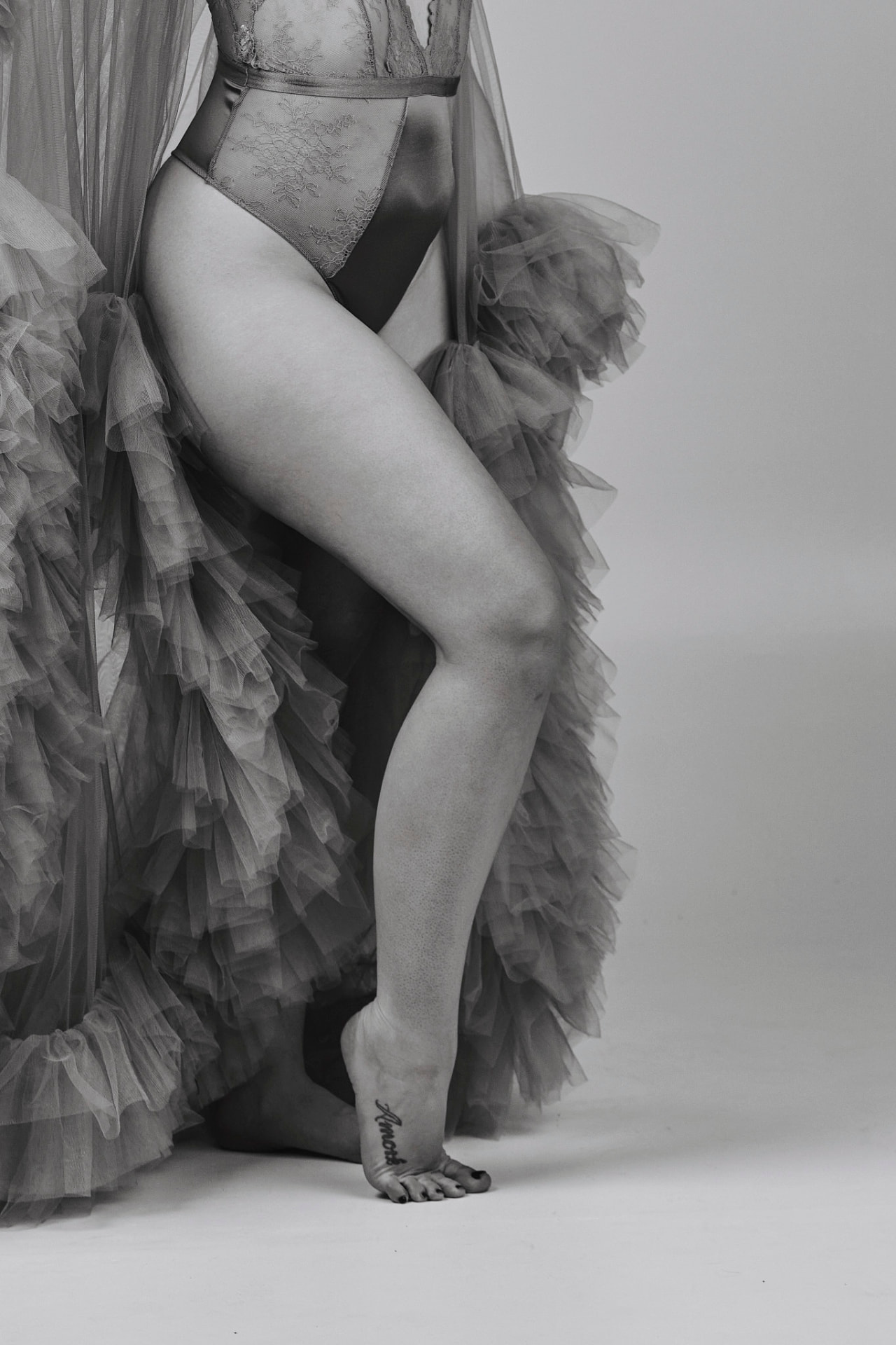 Black-and-white boudoir study of legs and tulle